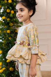Adorable girls' yellow checkered co-ord set by Laad India, featuring intricate floral and animal embroidery, ruffled peplum top, and comfortable wide-leg pants. A perfect blend of vintage charm and modern elegance for your little one."